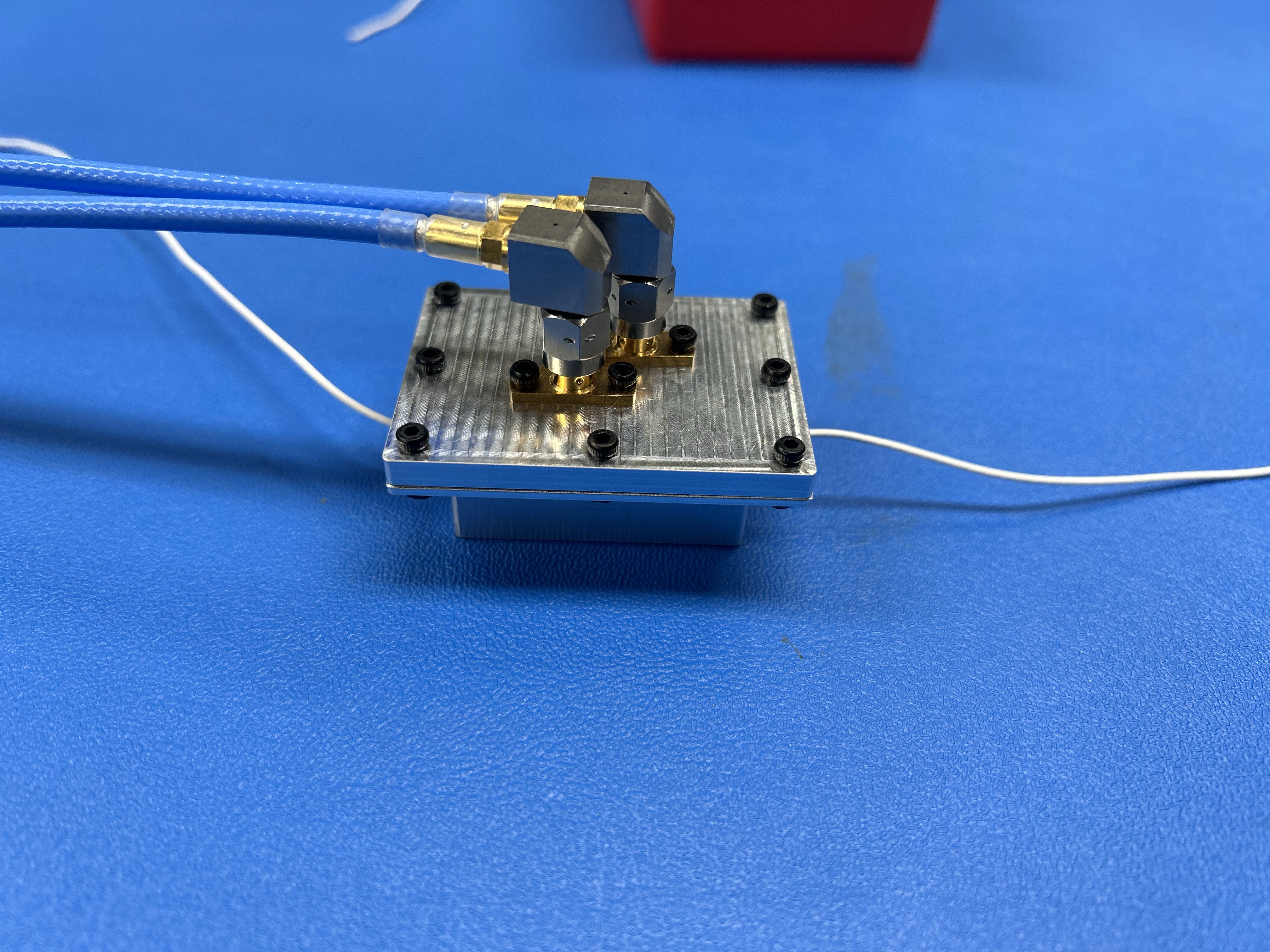 Cavity resonator connected to VNA cables with an ePTFE wire sample inserted